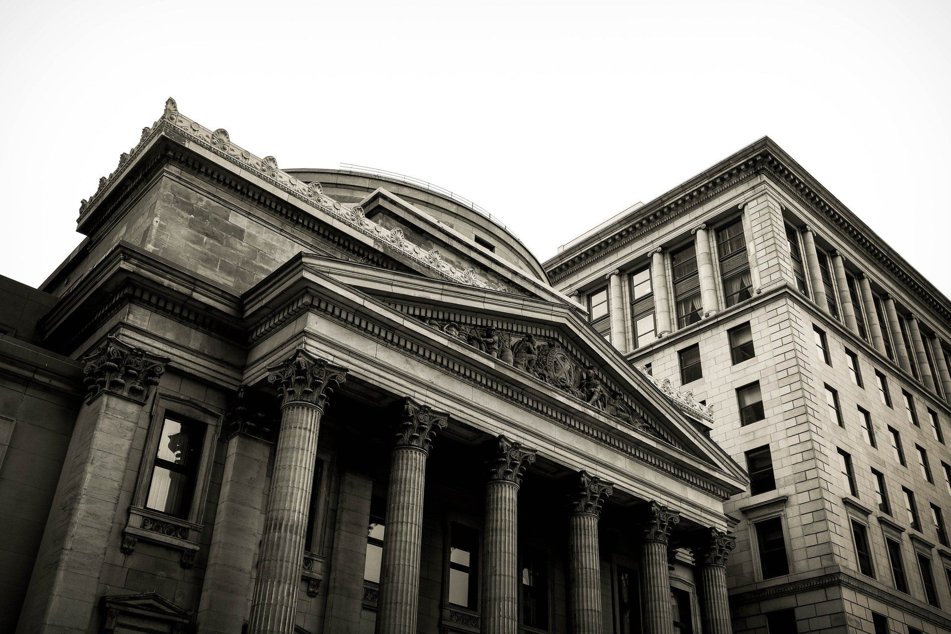 A black and white photo of a large building with columns and a dome.
